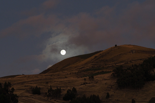 Moon setting against grass bank\n\n
