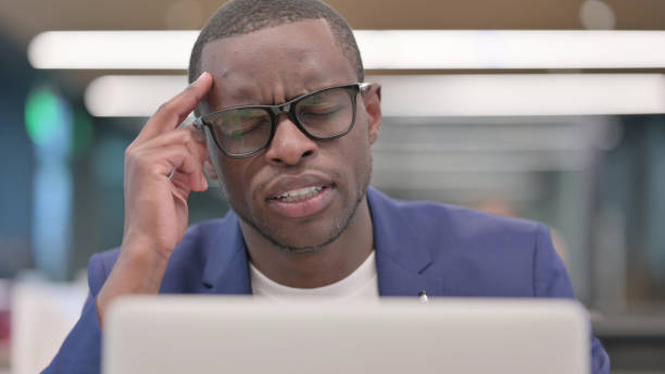istock African Businessman with Laptop having Headache 1330737628