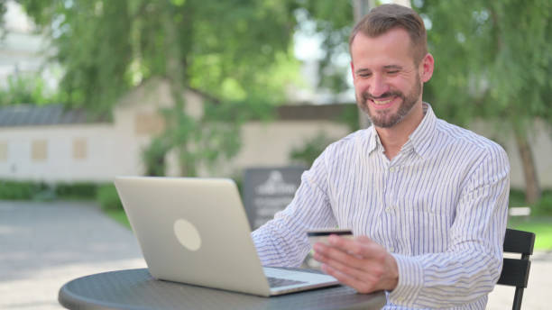 istock Successful Online Payment on Laptop by Middle Aged Man 1330739783