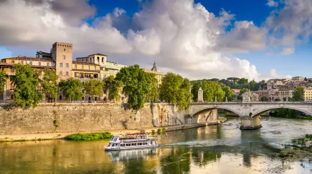 Photo of A pictorial summer scene of the historic heart of Rome with a tourist ferry sailing along the River Tiber