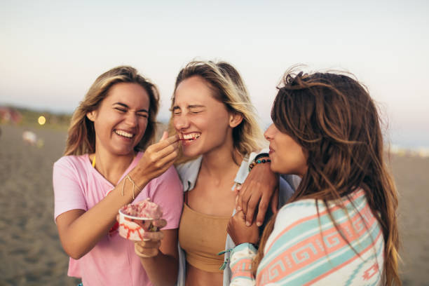 istock Girls eating ice cream on the beach, selective focus 1330744921