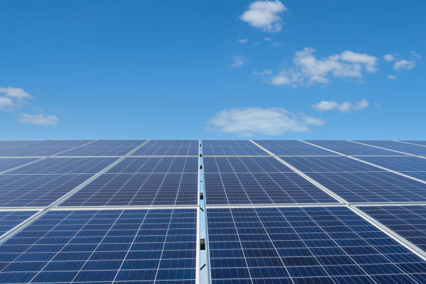 istock Row of solar panels on a solar farm under a blue sky. 1330746258