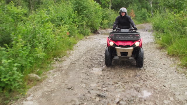 People Driving ATV in Forest
