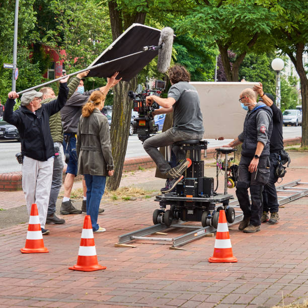 Hamburg, Germany, July 22, 2021: Film crew with reflector and wind-protected microphone filming on a sidewalk