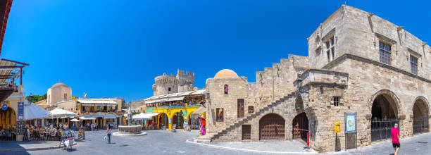 panoramic view sightseeing place at hot summer sunshine afternoon. tourists on hippocrates square at the rhodes old town main square of rhodes, greece - editorial built structure fountain town square imagens e fotografias de stock