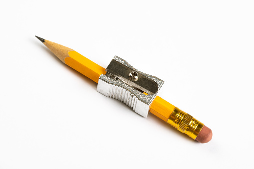 Extreme close-up of the end of a pencil resting on a blank sheet of white paper.