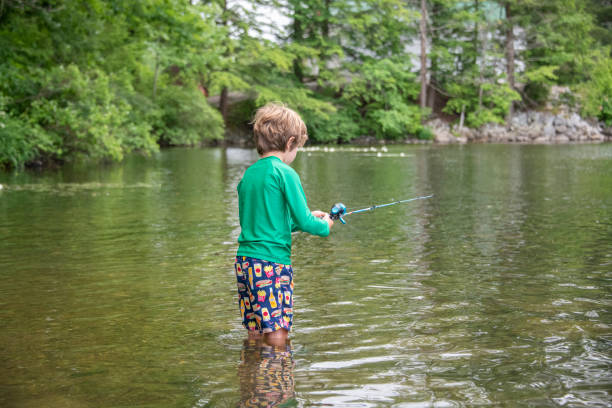 istock Young boy reels in a fish 1330756106