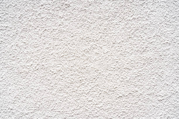Pebbledash wall exterior surface An exterior wall finished with a rough rendered surface, painted white. bumpy stock pictures, royalty-free photos & images