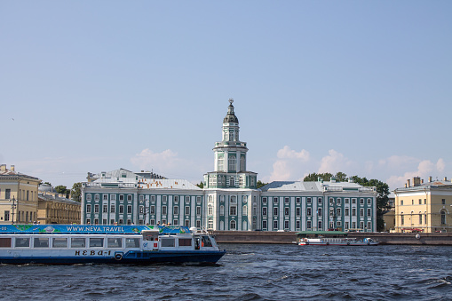 panoramic view of the historical building of the museum-Kunstkamera on the embankment of the Neva River and a tourist boat and a space for copying on a sunny in Saint-Petersburg