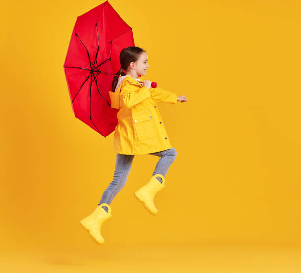 istock Happy kid with umbrella jumping in studio 1330757289