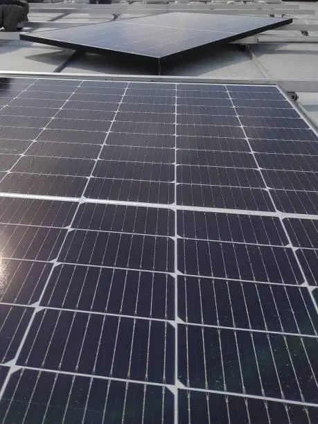 Photo of Closeup of photovoltaic panels on a rooftop. Reflecting photovoltaic modules on a rooftop.