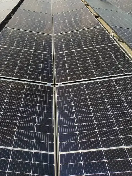 Photo of Closeup of photovoltaic panels on a rooftop. Reflecting photovoltaic modules on a rooftop.