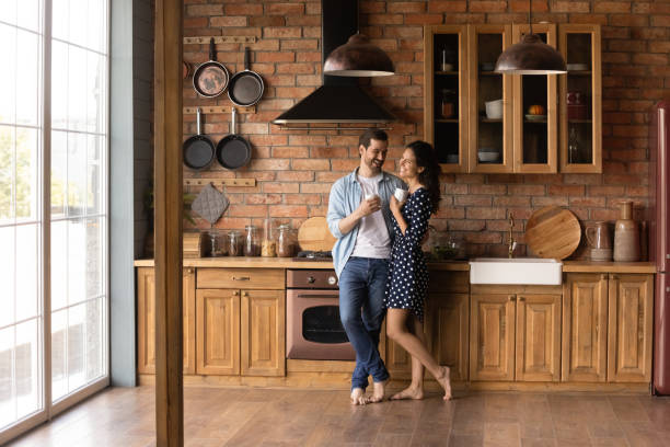 istock Happy young married couple enjoying morning coffee in kitchen 1330763437