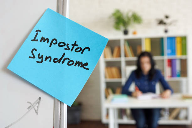 impostor syndrome written on the sticker on the whiteboard. - imitação imagens e fotografias de stock