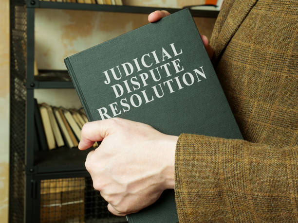 istock Man shows judicial dispute resolution JDR book. 1330765809