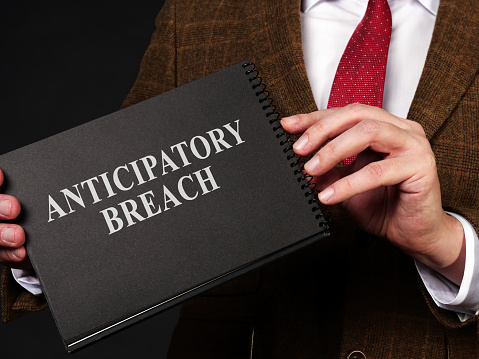 Man holds papers about anticipatory breach of contract.
