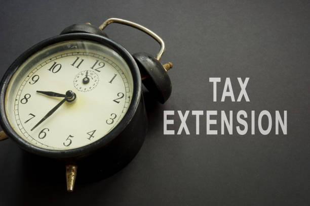 istock Old alarm clock and tax extension words. 1330765941