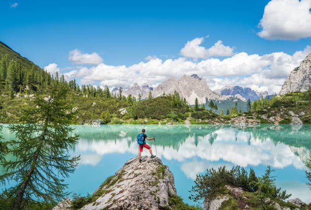 istock Backpacker with backpack enjoying the turquoise Lago di Sorapiss 1,925m altitude (mountain lake) view as he has mountain walk in Dolomite Mountains, Italy. Active people in nature concept. 1330766032