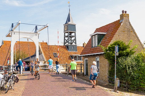 Locals and tourists walk on the quay of the picturesque town of Hindeloopen in Friesland.
