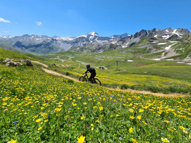 Woman riding a bike downhill in Tignes Bike Park in France stock photo