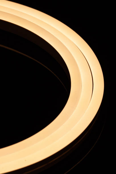 istock Flexible warm white led tape neon flex closeup on black background 1330771442