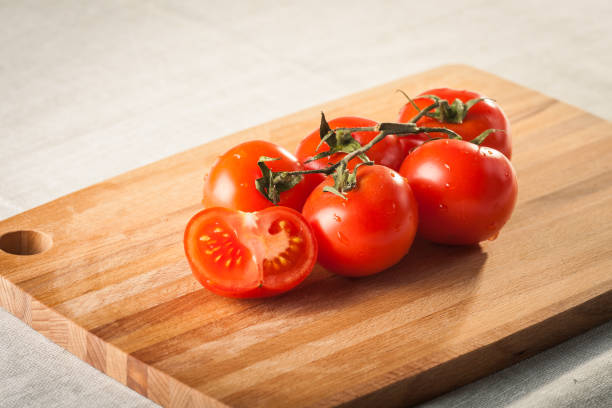 istock Fresh tomatoes on vintage wooden cutting board 1330773592