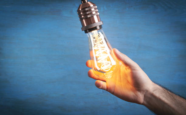 istock Male hand holding vintage modern light bulb. 1330773682