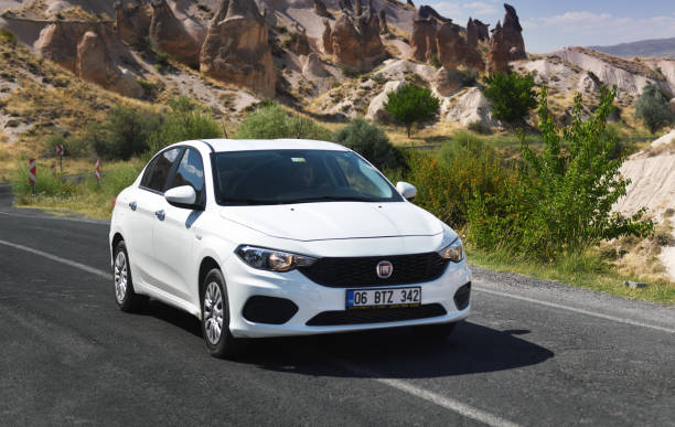 kappadokien, türkei 12.07.2021:weißer fiat tipo auf der autobahn in den bergen kappadokiens. fiat tipo ist ein kompaktwagen, der seit 2015 von fiat produziert wird. - sports car car business editorial stock-fotos und bilder