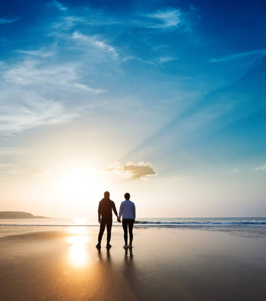 istock Romantic couple standing on beach at sunset 1330774991
