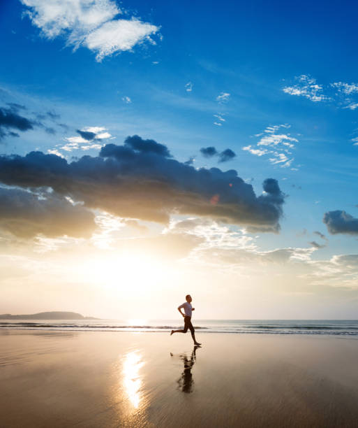 istock Man jogging on the beach at sunset 1330774992
