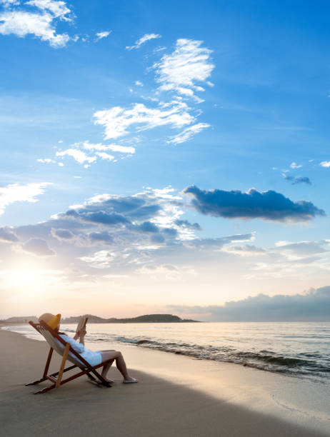 Woman reading a book by the sea.