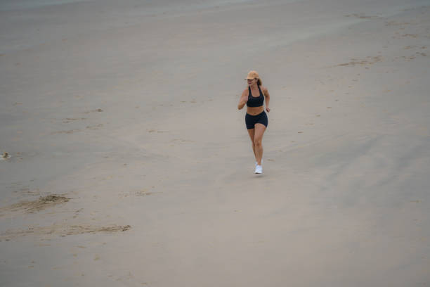 Shot of a handsome young man running on the beach
