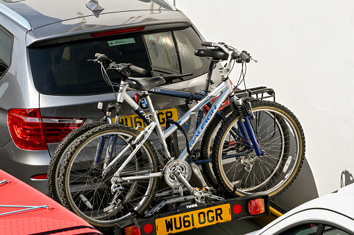 Poole, Dorset, England - June 2021: Bicycles on a bike rack on the back of a care.