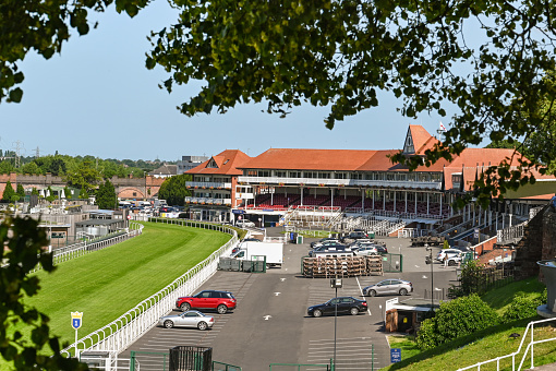 Chester, England - July 2021: Track and stand at the racecourse in Chester frame by trees. It is adjacent to the city centre.