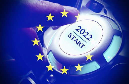 Human hand pushing the 2022 start button , with the European Flag, concept of starting a new year .