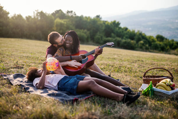 istock Happy mixed race family enjoying while relaxing on the field 1330781018
