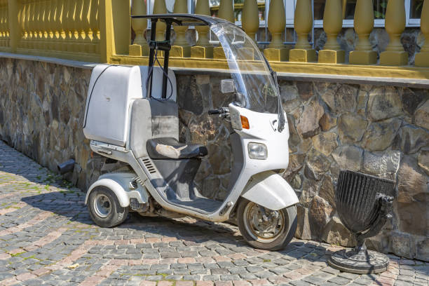 istock White compact 3-wheel scooter against a stone wall 1330782179