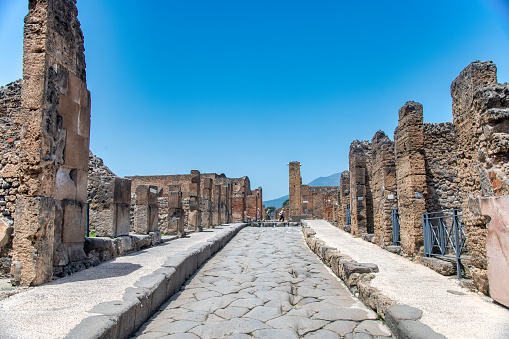 POMPEI, ITALY - JUNE 28, 2021: Tourists visit famous ruins of ancient city of Pompeii near volcano Vesuvio