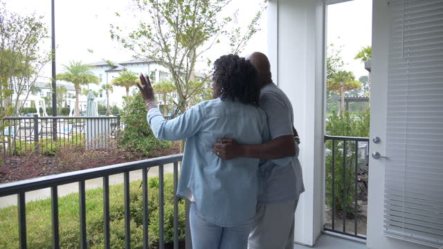 Senior black couple on apartment terrace looking at view