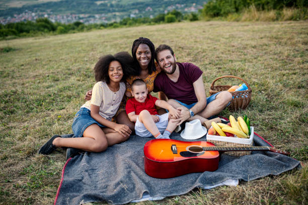 istock Happy mixed race family enjoying while relaxing on the field 1330786292