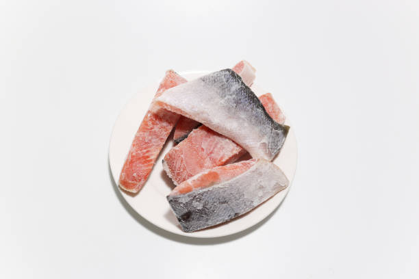 Pictured frozen salmon fillets in a white background.