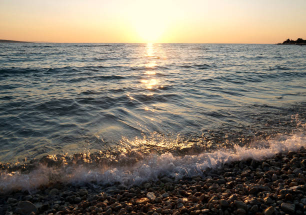 istock Beautiful sunset with flooding sea water on pebble beach 1330786480