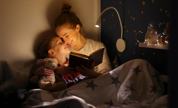 istock Cheerful mother and son cuddling and reading book 1330789469