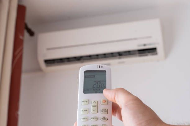 istock Man hand with remote control turn off air conditioning 1330791158