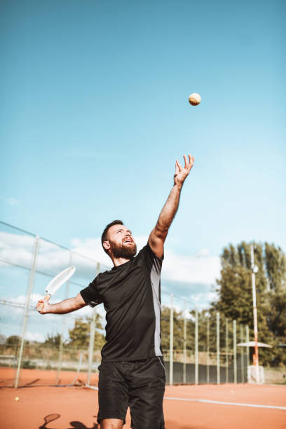 istock Focused Male Tennis Player Serving Ball 1330791483