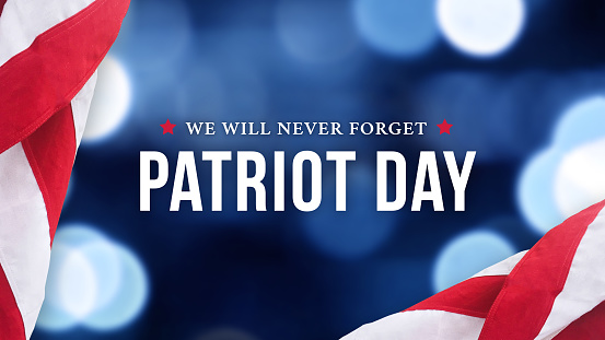 Día del Patriota - Nunca olvidaremos el texto sobre el fondo de las luces azules y las banderas estadounidenses photo