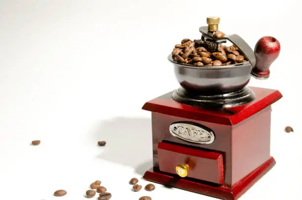 Mechanical manual retro coffee grinder. On a light background. Close-up. Coffee beans