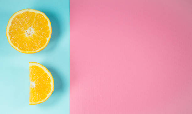 istock Orange slices on trendy pastel blue and pink background 1330795282