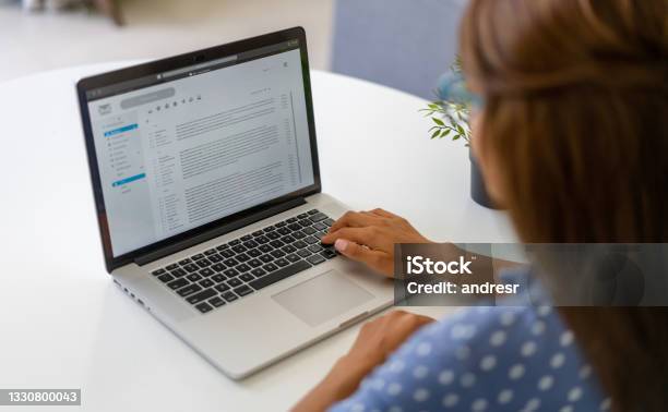 Woman Working At Home And Reading Emails On Her Laptop Stock Photo - Download Image Now