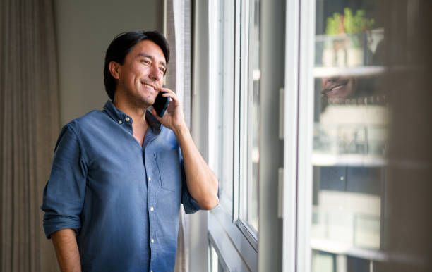 istock Latin American man at home talking on the phone 1330800111